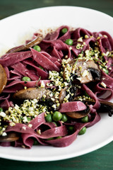 Fideos de remolacha con crocante, arvejas y champignones
