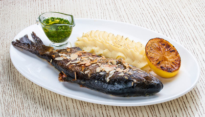 Baked trout with almonds and mashed potatoes. On white background