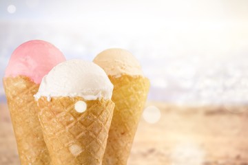 Chocolate, vanilla and strawberry ice cream in the cones on white background