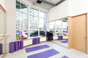 Empty space in fitness center, white brick walls, natural wooden floor and big windows, modern loft...