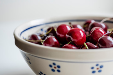 Healthy snack of shiny, red bing cherries in Polish pottery bowl