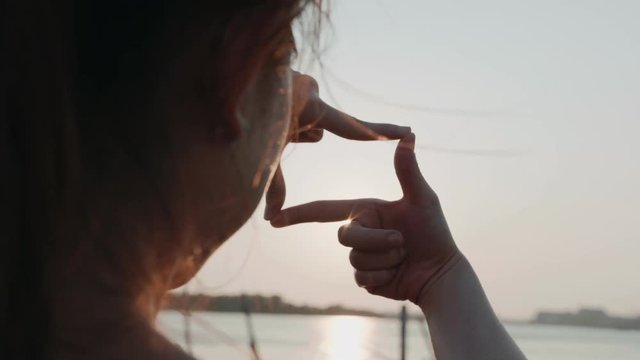 Future planning, Closeup of woman hands making frame gesture with sunrise, Female capturing the sunrise, sunlight outdoor.