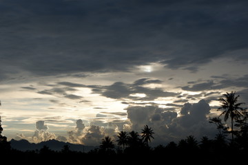 sunset view that emits sunlight against a background of cloudy sky