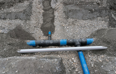 laying large industrial water pipes in an earth and dirt ditch for water supply and irrigation