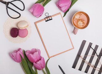 Feminine styled work place with tulips and coffee.