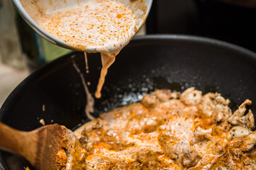 wlewanie sosu w trakcie smażenia kurczaka