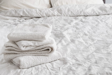 Clean white towels on the white bed