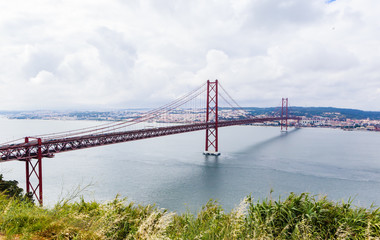 Ponte 25 de Abril Bridge in Lisbon, Portugal. Connects the cities of Lisbon and Almada crossing the Tagus River. View from Almada with Lisbon across