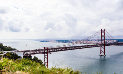 Ponte 25 de Abril Bridge in Lisbon, Portugal. Connects the cities of Lisbon and Almada crossing the Tagus River. View from Almada with Lisbon across