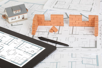 Model house construction with brick on blueprint