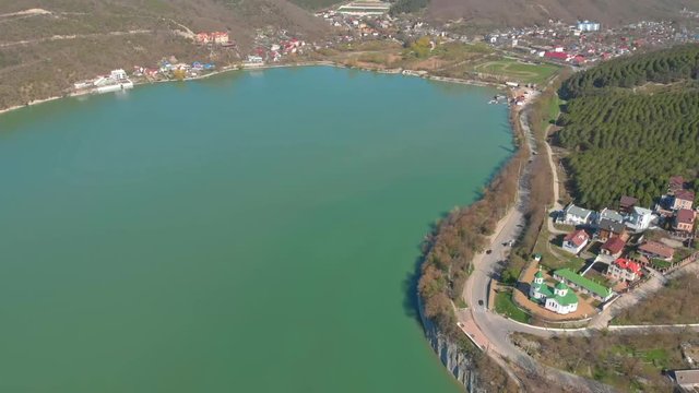 Church on the shore of Lake Abrau, shot from the drone. Beautiful futage of a quiet village and church by the lake