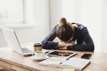 Tired and overworked business woman. Young exhausted girl sleeping on table during her work using...