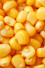Golden canned corn, as distributed on a plane background and texture of popcorn. Before watching a movie top view. Close-up