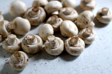 Champignon mushrooms on marble background. Top view, selective focus.