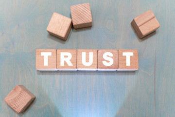 Trust integrity business industry concept on a wooden blocks background.