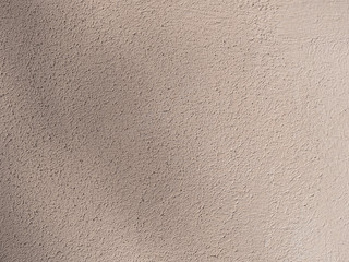 Beige painted wall. Rough light brown texture.