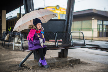 Little child waiting on a railway train station.