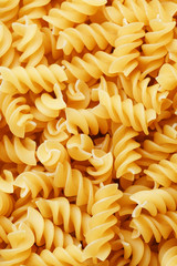 Background texture and pattern of boiled egg noodles in a spiral or pasta spaghetti screw. in full frame. View from above