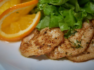 Meat roasted on fire with lemon and green salad.
