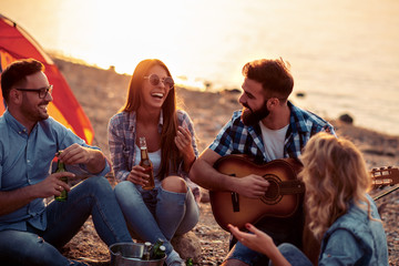 Friends are camping and playing guitar