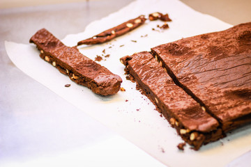 The girl's chef slicks the brownies. Delicious cakes. Brownies with chocolate and nuts.