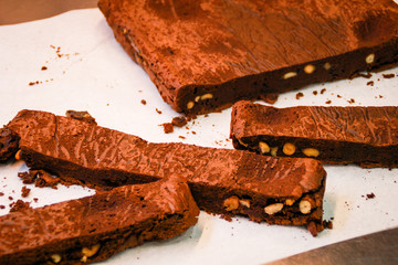 The girl's chef slicks the brownies. Delicious cakes. Brownies with chocolate and nuts.
