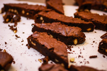The girl's chef slicks the brownies. Delicious cakes. Brownies with chocolate and nuts.