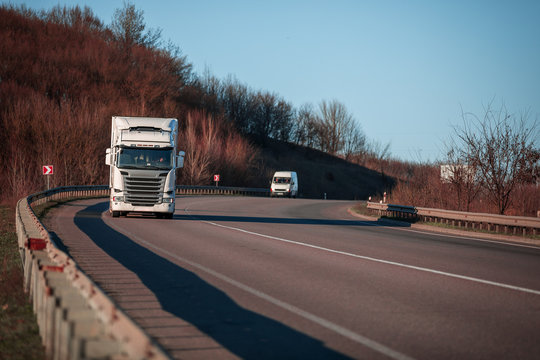 Arriving White Truck On The Road In A Rural Landscape At Sunset