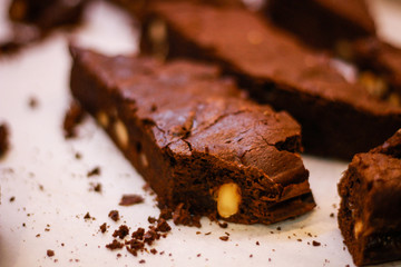 The girl's chef slicks the brownies. Delicious cakes. Brownies with chocolate and nuts.