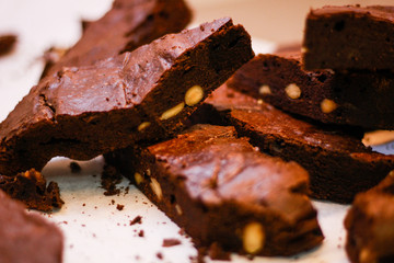 The girl's chef slicks the brownies. Delicious cakes. Brownies with chocolate and nuts.