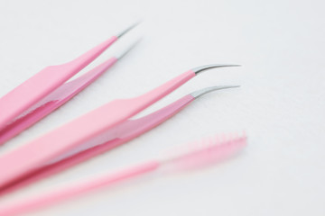 Eyelash extension procedure tools. Pink tweezers, tongs and brush. Instruments for lengthening...