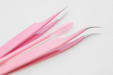 Eyelash extension procedure tools. Pink tweezers, tongs and brush. Instruments for lengthening lashes. Beauty Concept. Flat lay composition accessories. Artificial eyelashes. Minimalism.