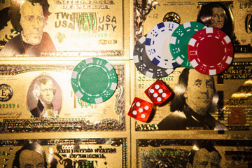 Casino red dices and casino poker chips on golden US Dollar bills