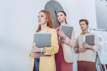 attractive women and handsome man waiting in line with folders