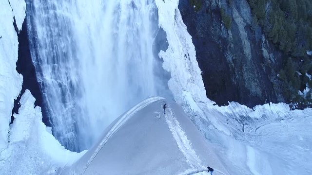 A man takes photos of a huge waterfall in Quebec city (Canada).