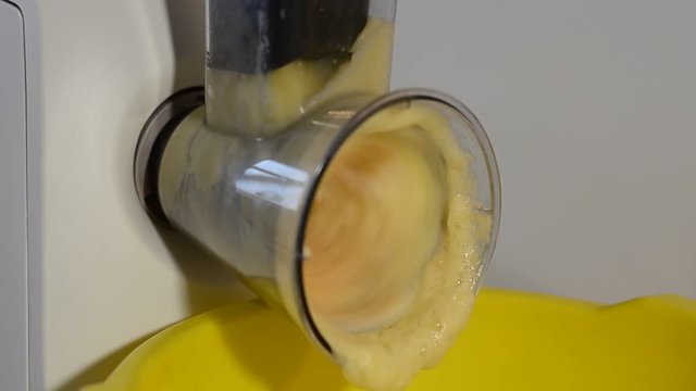 Electric grater cuts raw potatoes