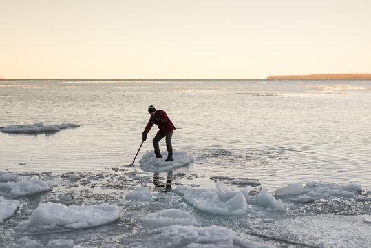 Man balanced on floating ice comes into shore