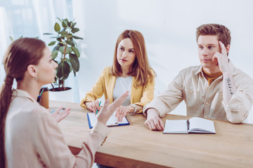 woman talking and gesturing near recruiters on job interview