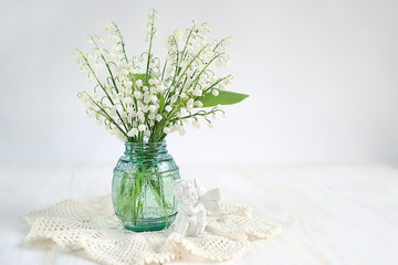 bouquet of lilies of valley and angel. spring season, concept  spring holiday, congratulations. hello spring, springtime blooming. copy space  Lily of the valley day in France, Le jour du Muguet