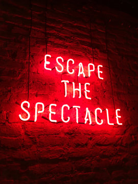 Escape the spectacle neon sign