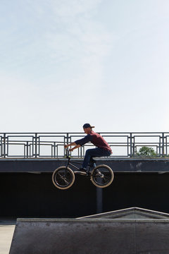 Young guy jumping on bike