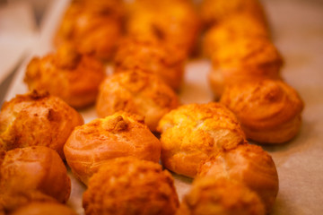Delicious eclairs. Bakery in the oven. Confectionery. Yellow small ecriles