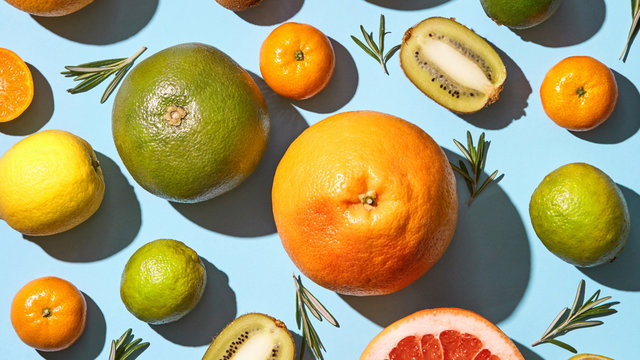 Fresh tropical fruits with rosemary on blue background