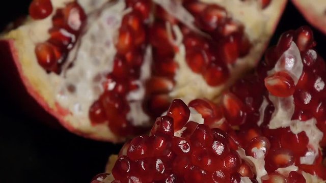 Portion of fresh made pomegranate. Fresh red pomegranate seeds isolated on a black background. Close-up.