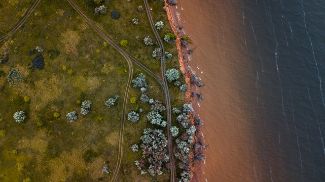 Aerial view of the sandy waves diffusing in the water near the river bank