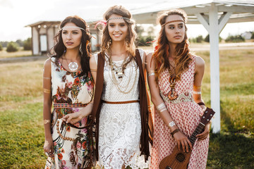 Three cute beautiful hippie girl in the setting sun, outdoors, the best of friends smiling and...