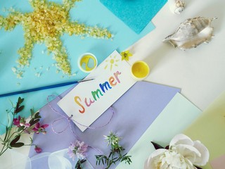 Postcard summer, the sun from sea salt, fresh flowers, colored paper, brushes - the concept of congratulations on the summer, seasonal decorative composition
