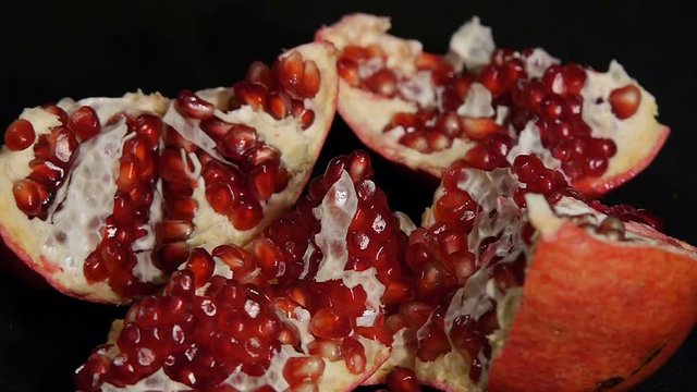 Delicious pomegranate. Portion of fresh made pomegranate isolated on a black background.