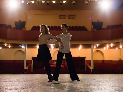 Artistic couple dancing on theater stage