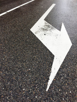 arrow on wet asphalt road